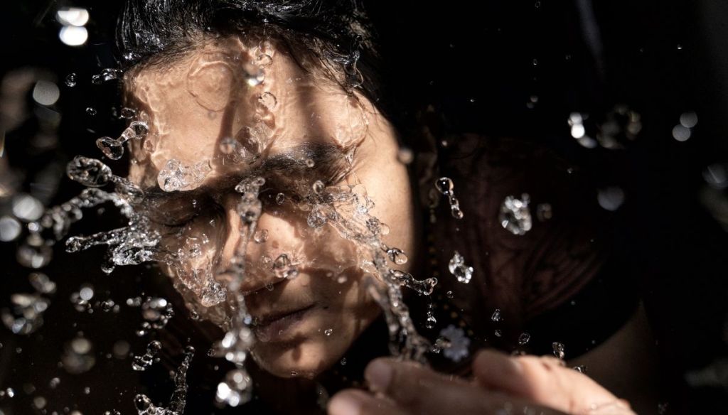 girl washes face splash water