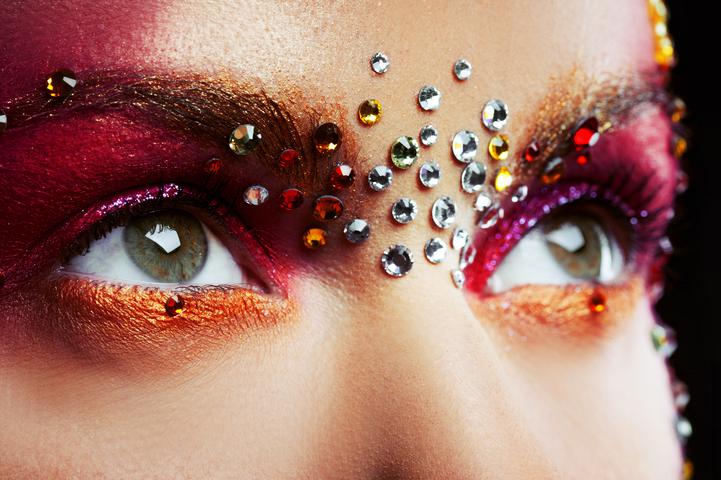 Shiny makeup can be done using shimmer and rhinestone stickers